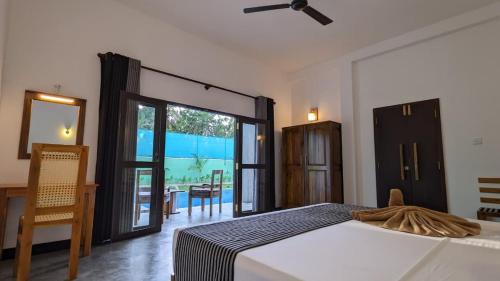 a bedroom with a bed and a sliding glass door at Ima villa in Tangalle