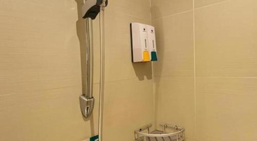 a shower in a bathroom with a scale on the wall at City Comfort Inn Hotel Zigong Wanda Plaza in Zigong