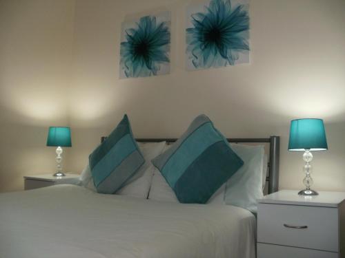 1 dormitorio con 1 cama con 2 lámparas en London Heathrow Guesthouse, en Hillingdon