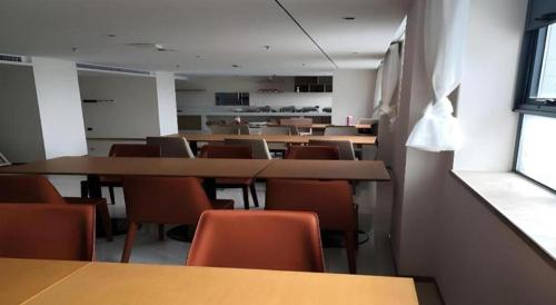 an empty room with tables and chairs in a classroom at City Comfort Inn Kunshan High-speed Railway Station Renmin Road in Suzhou