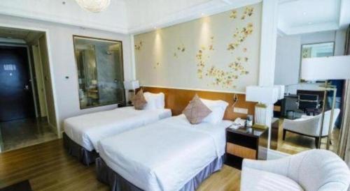 a hotel room with two beds and a desk at Ming Guan Hotel in Sihanoukville