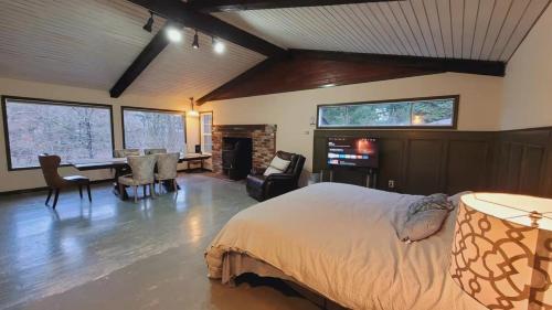 a bedroom with a bed and a desk and a fireplace at Riverside Home With a Rustic Charm in Washougal