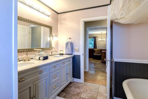 a bathroom with a sink and a mirror and a tub at Riverside Home With a Rustic Charm in Washougal