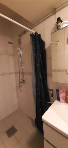 a bathroom with a shower with a black shower curtain at Wonderful Stay Helsingborg in Helsingborg