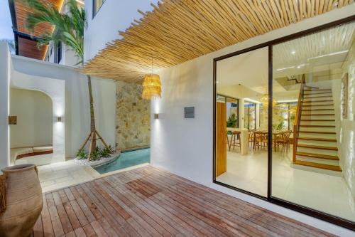 Anjuna Surf & Sunset 2BR Villas in Uluwatu في أُلُواتو: غرفة معيشة بها درج ومنزل