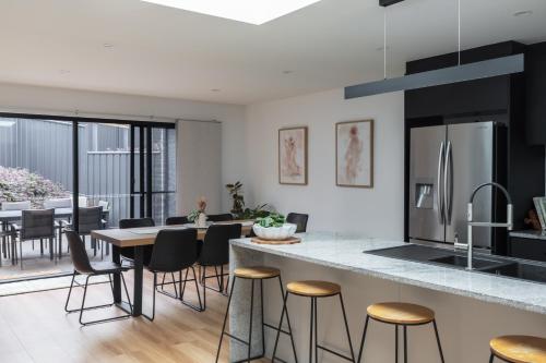 an open kitchen and dining room with a table and chairs at The Crescent, a modern townhouse near LGH & parks in Kings Park