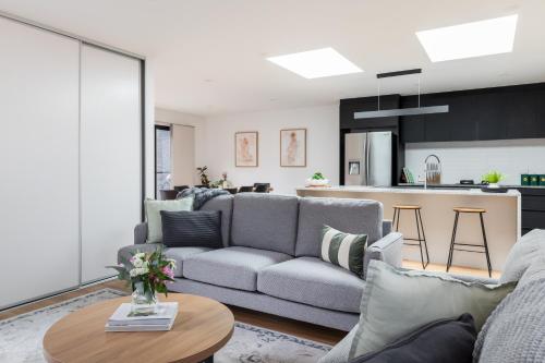 a living room with a couch and a table at The Crescent, a modern townhouse near LGH & parks in Kings Park