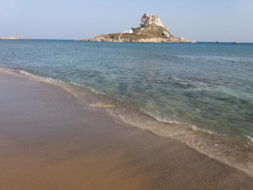 a sandy beach with an island in the water at Maritsa in Kefalos