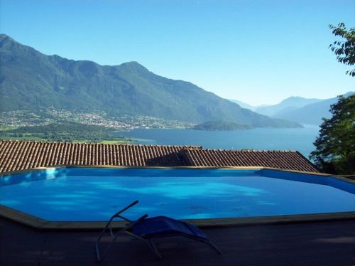 a large blue swimming pool with an umbrella on a roof at Casa delle Camelie in Sorico