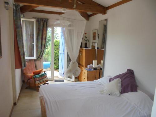 a bedroom with a white bed and a large window at Les ailes d'un reve in Vidauban