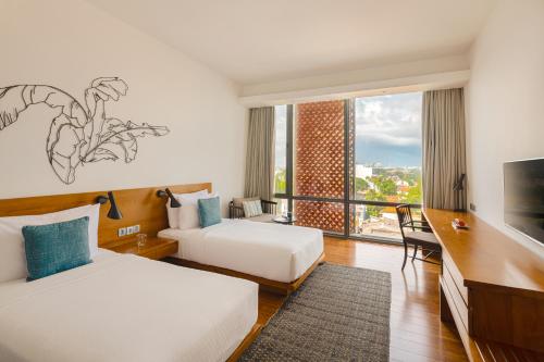 a hotel room with two beds and a large window at Jetwing Colombo Seven in Colombo