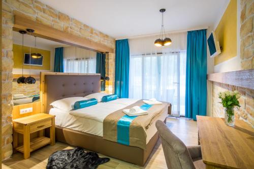 Habitación de hotel con cama, mesa y escritorio. en Luksuzne sobe Luce en Vrbnik