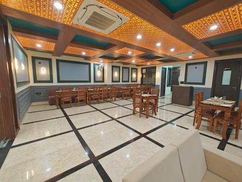 a dining room with tables and chairs and a room with a ceiling at Hotel The Rajwada LP in Lucknow