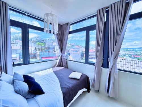 a bedroom with a bed and windows with a view at Lantana Homestay in Da Lat