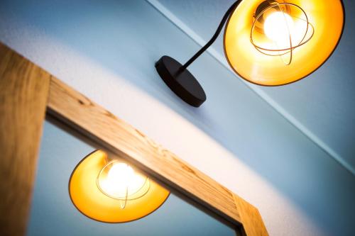 two lights hanging from the ceiling next to a mirror at Anna 1908 in Berlin