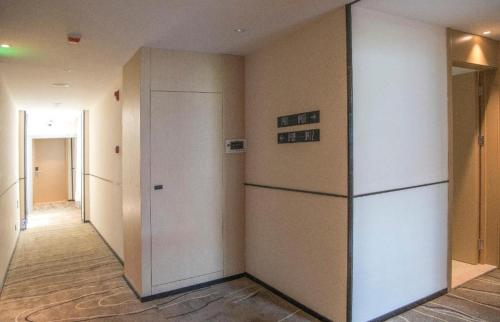 an empty hallway with a refrigerator in a building at City Comfort Inn Qianjiang Government in Qianjiang