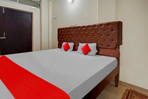 a bedroom with a bed with red and white pillows at Super Hotel O Home Town in Patna