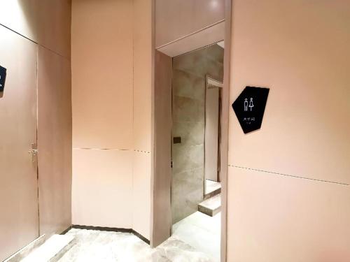 un pasillo con escaleras y un cartel en la pared en Echarm Hotel Wuhan Gaotie Jianshe 2nd Road Metro Exit, en Wuhan
