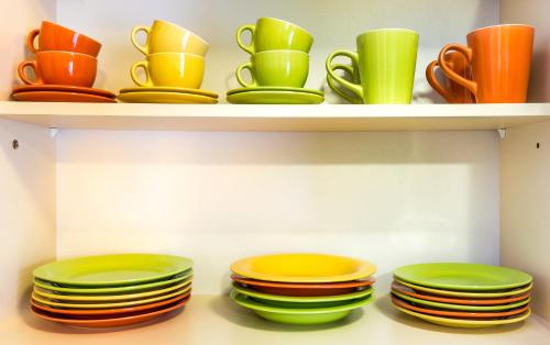 a shelf filled with colorful plates and cups and dishes at Rooms & Apartments Kepic, AIRPORT accomodation in Cerklje na Gorenjskem