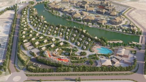 an overhead view of a resort with a river and houses at T-Rex Glamping in Dubai
