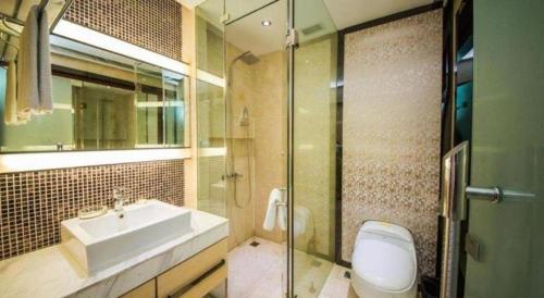 a bathroom with a sink and a toilet and a shower at Milu Hotel in Guangzhou