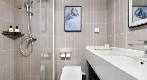 a bathroom with a shower and a toilet and a sink at Jinjiang Inn Shenzhen Airport in Shenzhen