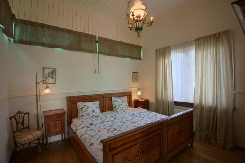 a bedroom with a bed and a chair and a chandelier at Halte Sint-Gerlach Holiday Home in Valkenburg