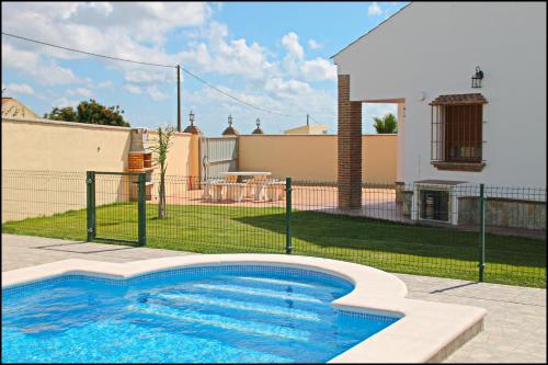 una piscina en un patio con una casa en Chalet Vigía 114, en Conil de la Frontera