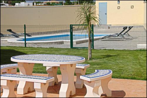 コニル・デ・ラ・フロンテーラにあるChalet Vigía 114のプール付き公園内のテーブルと4台のベンチ