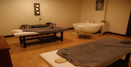 a room with a bath tub and a table and a bath tub at Daosavanh Resort & Spa Hotel in Savannakhet