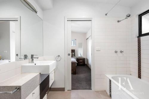 a white bathroom with two sinks and a tub at Pet Friendly, Flex Check-InOut, Australiana Touch in Geelong West