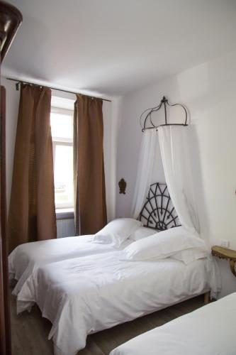 a bedroom with a large bed with white sheets at B&B La Loggia Del Castello in Trento