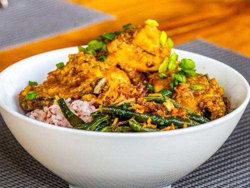 eine weiße Schüssel, gefüllt mit Essen auf Reis in der Unterkunft Shankara Forest Haven Villa by AGATA in Jatiluwih