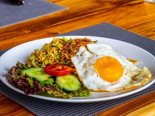 einen Teller mit einem Ei und Salat in der Unterkunft Shankara Forest Haven Villa by AGATA in Jatiluwih