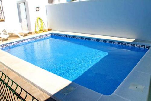 een groot zwembad met blauw water bij Chalet Arroyo Peñuelas 41 in Conil de la Frontera