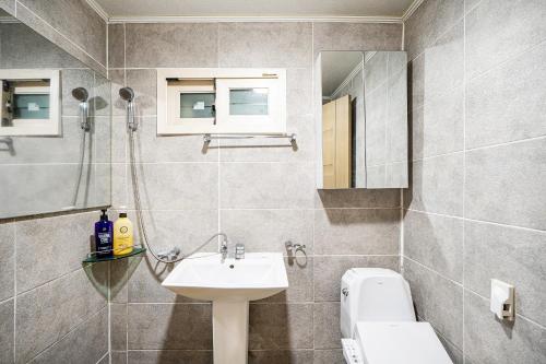 a bathroom with a sink and a toilet and a mirror at Yonghyun's house in Wando