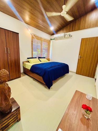 a bedroom with a blue bed and a wooden ceiling at Elure Stays in Pātalpāni