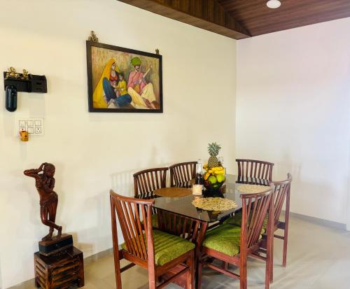 a dining room table and chairs with a painting on the wall at Elure Cafe and Stays 