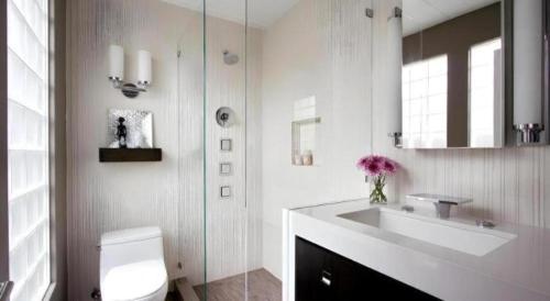 a white bathroom with a sink and a toilet at Umah Bali Suites in Denpasar