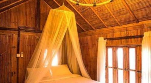ein Schlafzimmer mit einem Bett mit Moskitonetz in der Unterkunft Baansuanpai Noppakao in Mu Si