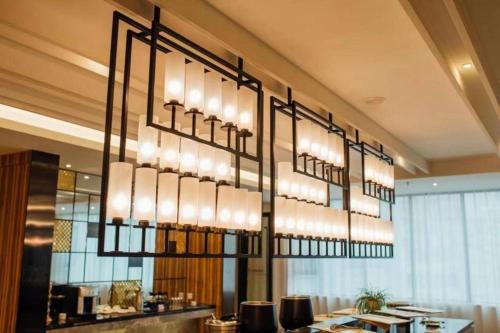 un lampadario pendente appeso al soffitto in un ristorante di Echeng Hotel Qinzhou Bay Plaza East High-speed Railway Station a Qinzhou