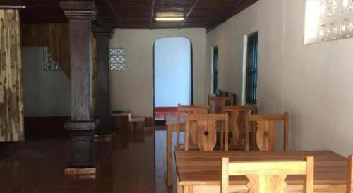 a room with a row of wooden tables and chairs at Sysomphone G.H in Luang Prabang