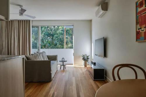 a living room with a couch and a television at Studio 34 Bayshore Drive in Byron Bay