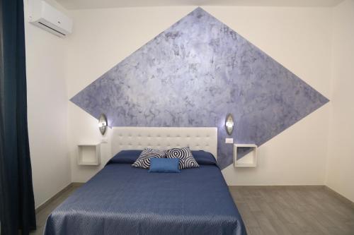 ein Schlafzimmer mit einem Bett mit einer lila Wand in der Unterkunft B&B Mimì in Castelsardo
