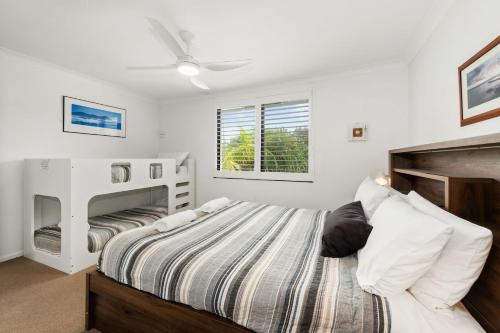 a bedroom with a bed and a crib at Atlantis 6 - 70 Lawson Street in Byron Bay