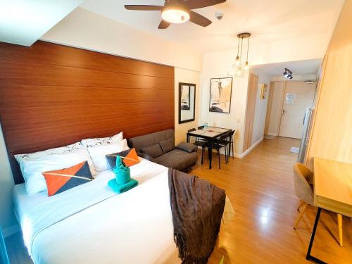 une chambre avec un grand lit avec une tête de lit en bois dans l'établissement 1203BT3 Solinea Resort Condo Unit Queen Bed Ayala Center, à Cebu