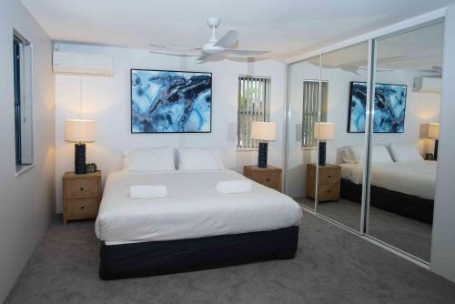 a bedroom with two beds and two mirrors at Nautilus 1 - 1- 46 Lawson Street in Byron Bay