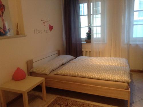Un pequeño dormitorio con una cama y una mesa. en Casa Similde e Casa Dolasilla in centro, en Bolzano