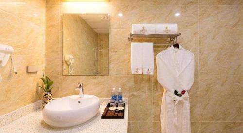 a bathroom with a sink and a white robe at Kim Bao Hotel in Hải Dương
