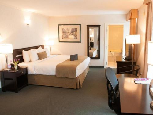 a hotel room with a large bed and a desk at Coast High Country Inn in Whitehorse